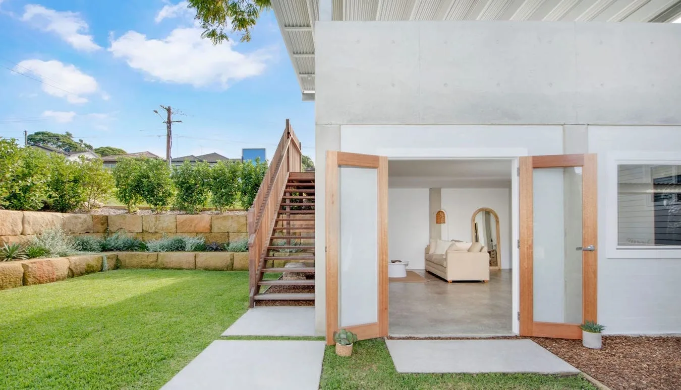 Backyard with a retaining wall and level lawn beside a home