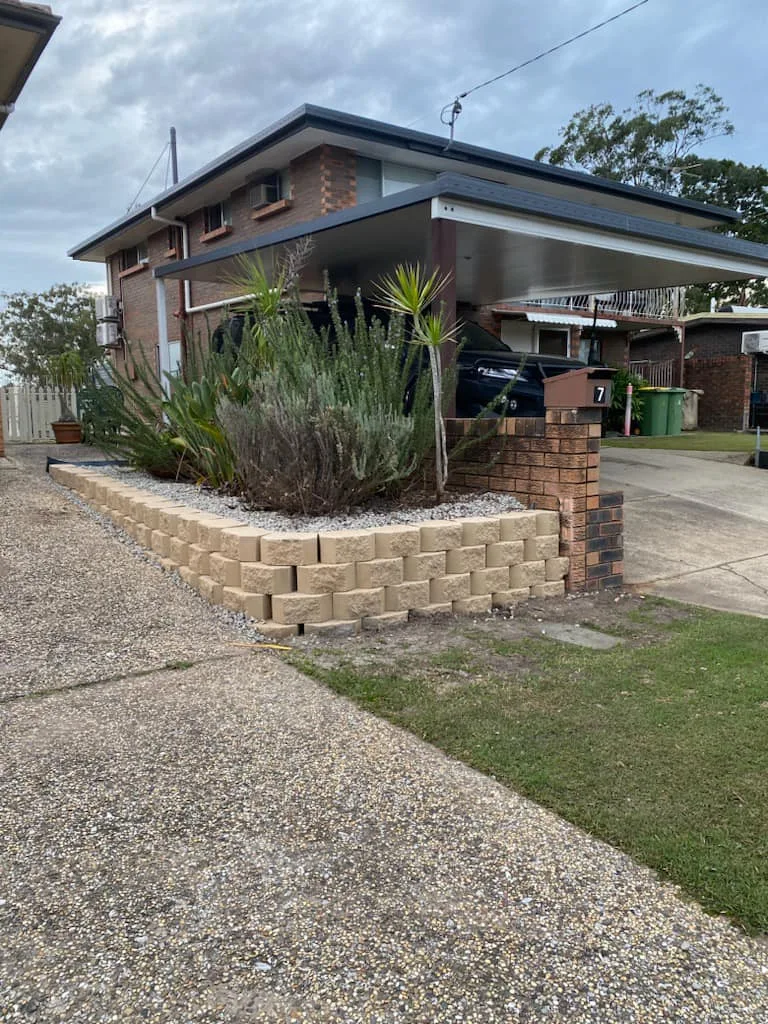 Sandstone-look block retaining wall around a front garden