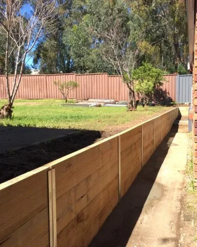 Long timber retaining wall along a backyard boundary
