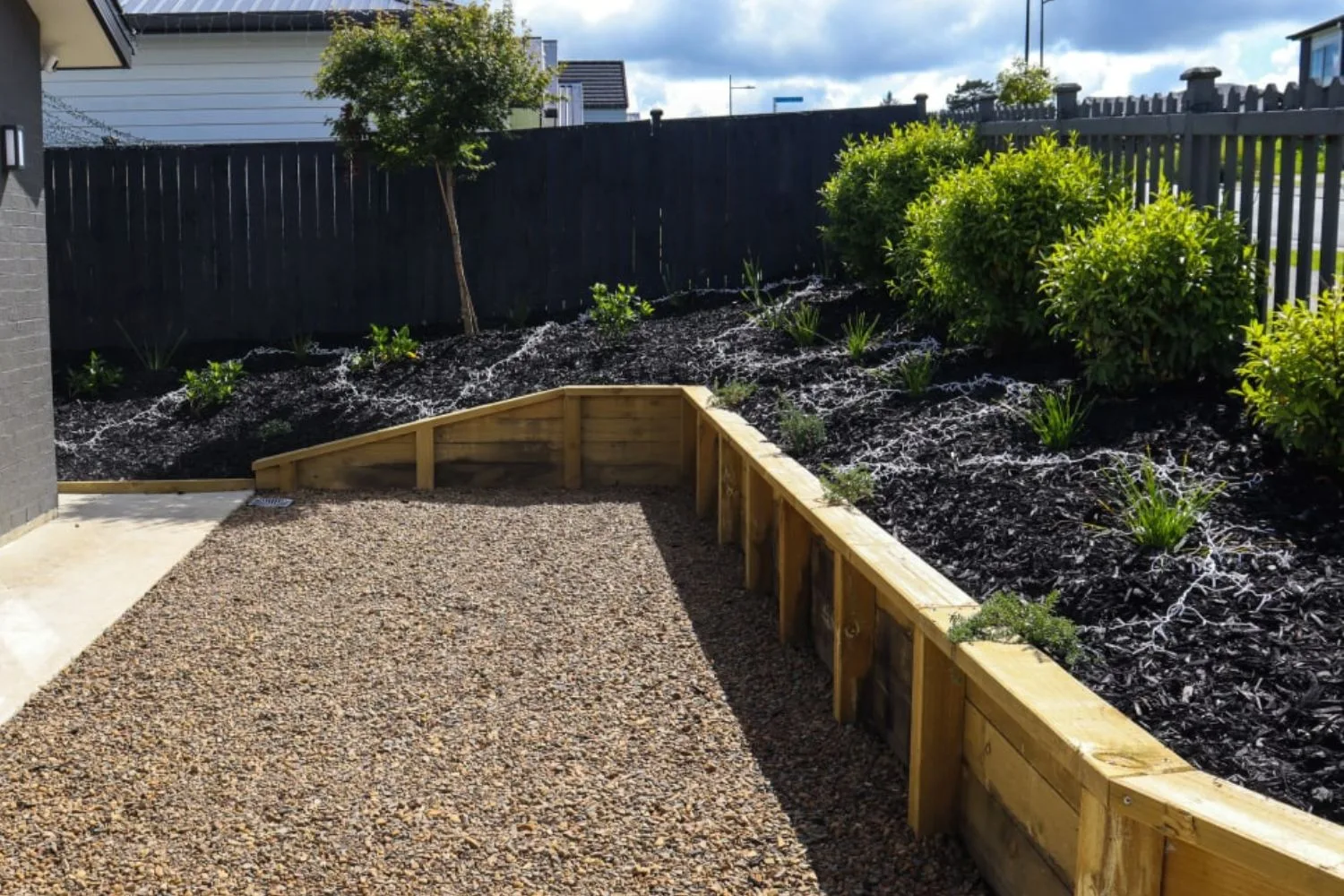 Treated pine timber retaining wall around a gravel area
